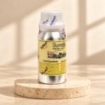 Surrati Oud Interlude perfume oil bottle on a pale travertine pedestal